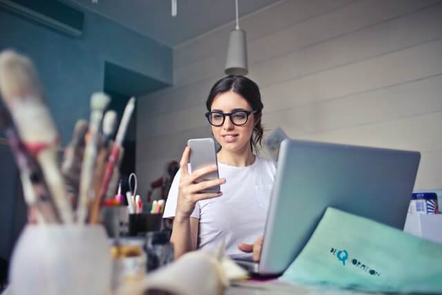 Woman in white shirt using a smartphone.