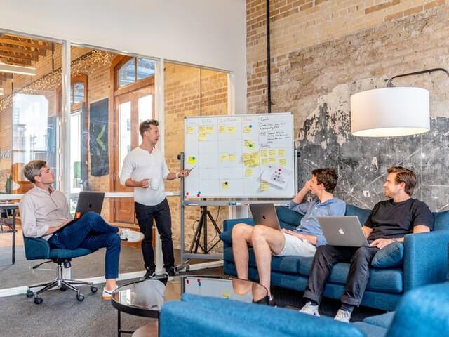 A group of coworkers in an office giving a presentation.