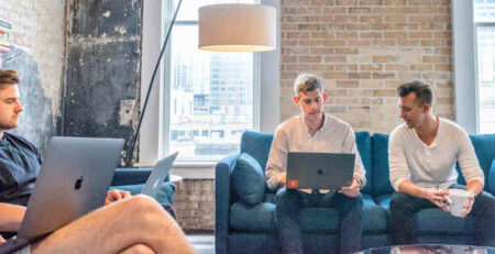 Three men sitting on couches in an office.