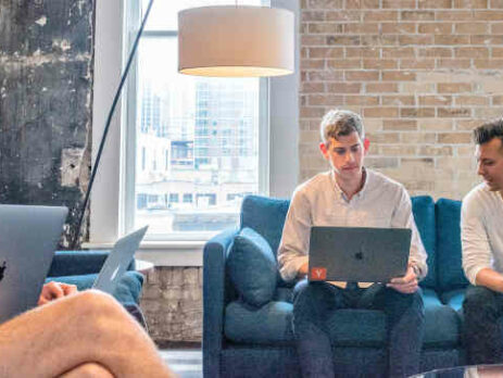 Three men sitting on couches in an office.