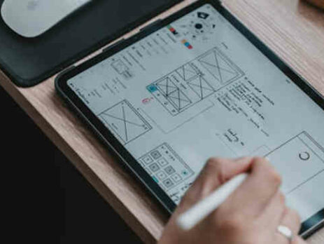 Image of UI designer writing on digital pad.