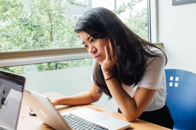 Woman sitting on a chair with laptop.