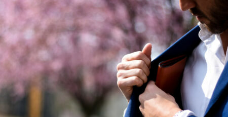 A man in a blue suit reaches for his wallet.