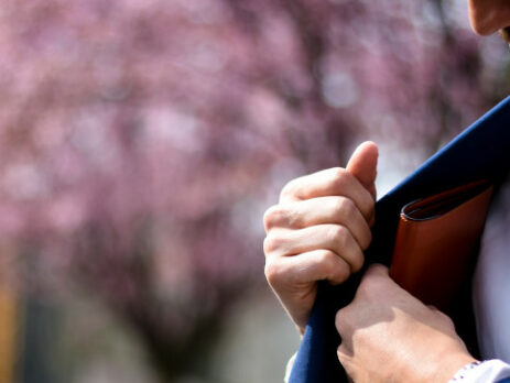 A man in a blue suit reaches for his wallet.