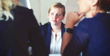 Three women in a meeting.