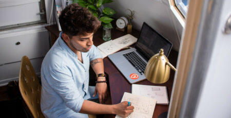 Man sitting at a desk and working on a computer.