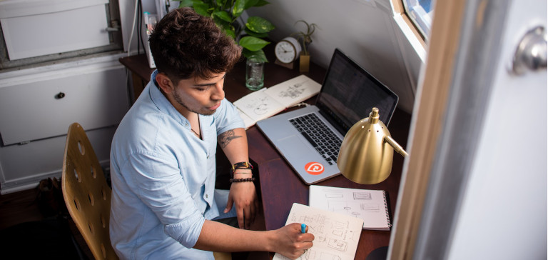 Man sitting at a desk and working on a computer.