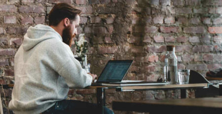 A man working on a laptop in a cafe.