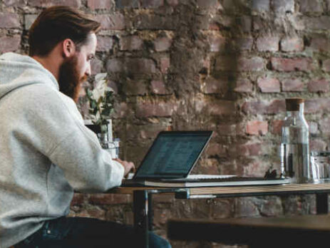 A man working on a laptop in a cafe.