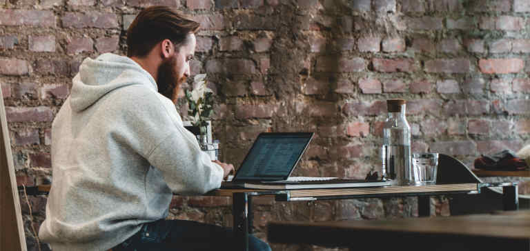 A man working on a laptop in a cafe.