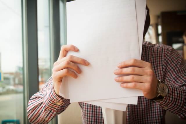 A man holding several sheets of paper.