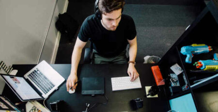 A man sitting at a desktop computer working.