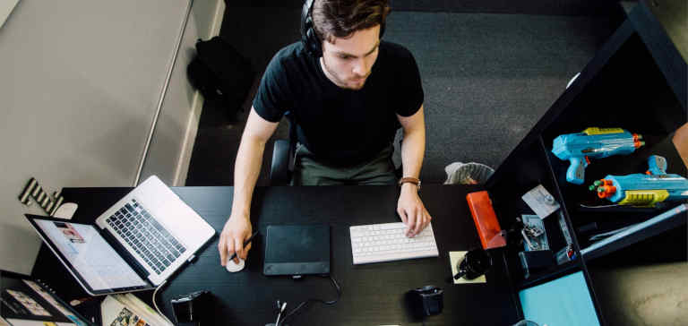A man sitting at a desktop computer working.