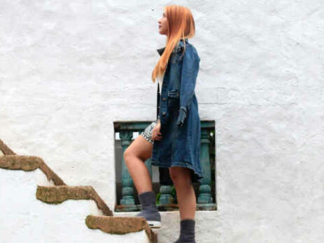 A redheaded woman climbs a staircase.