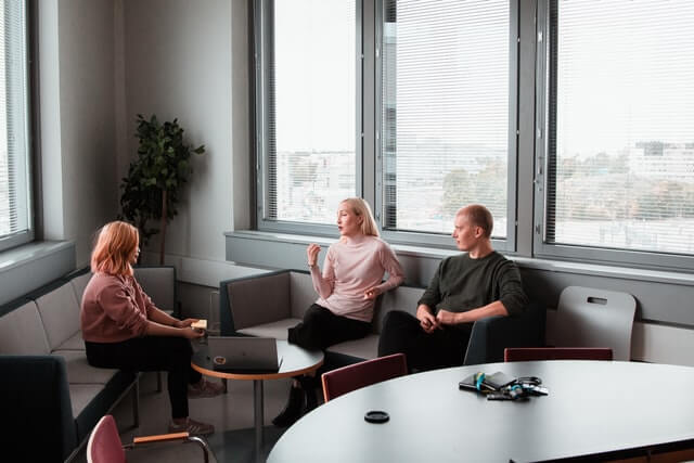 Three people sit together in a business meeting.