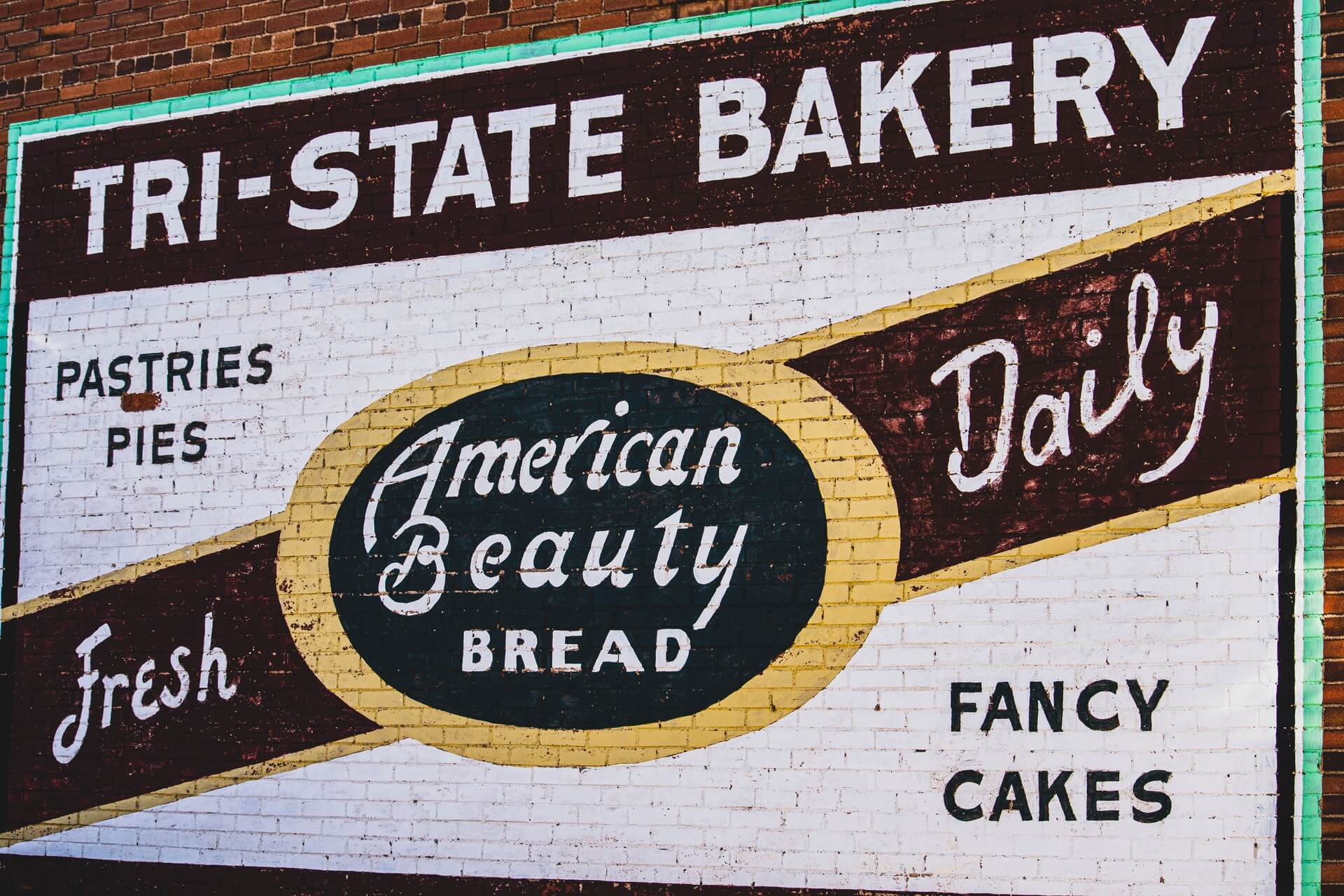 A painted advertisement for a bakery on a brick wall.