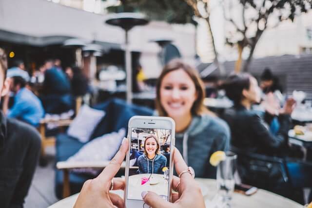 A girl has her photo taken with a smartphone.