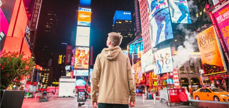 A man looks at advertisements in Times Square.