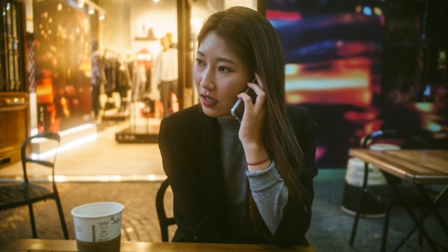 A woman talks on a cell phone inside a cafe.