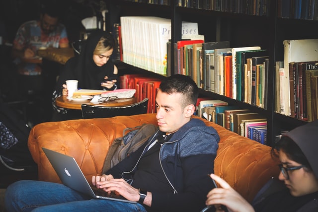People sit inside a cafe while they work on their computers.