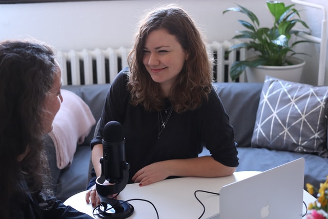 Two women speak into a microphone.