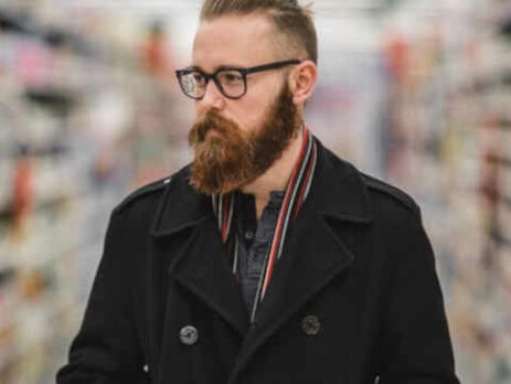 A bearded man shopping in a supermarket.