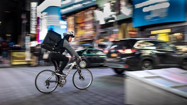 A person makes a delivery by bicycle.