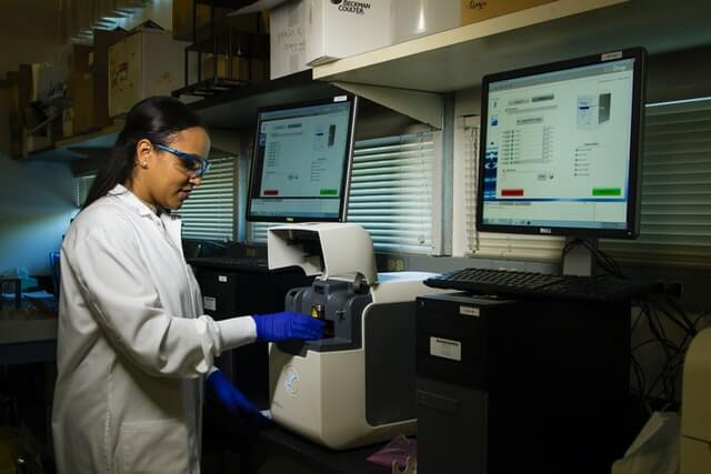 A doctor works in a laboratory near computers and medical equipment.