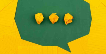 Three pieces of crumpled up yellow paper on a green background