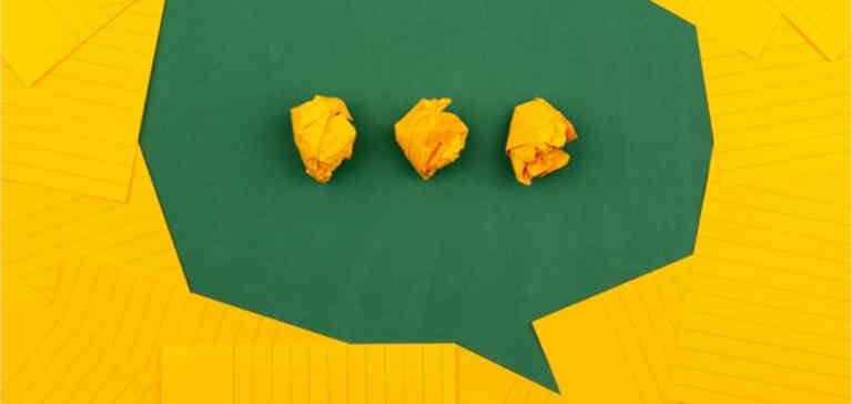 Three pieces of crumpled up yellow paper on a green background