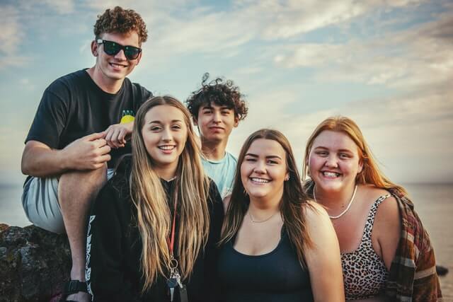 Five people stand outside and smile for the camera.