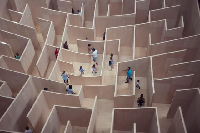 People and families walk around a maze.