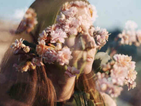 A double exposure of a woman and some flowers.