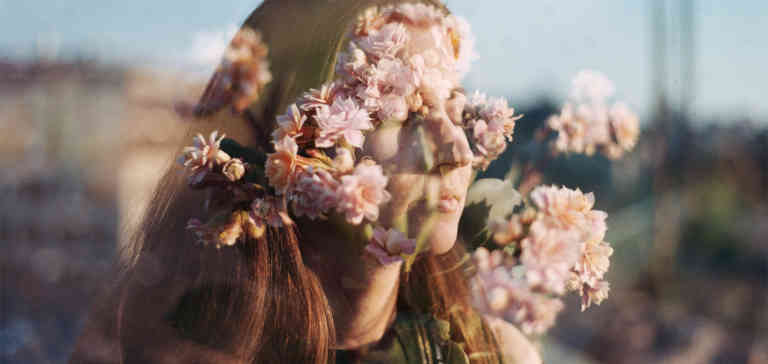 A double exposure of a woman and some flowers.