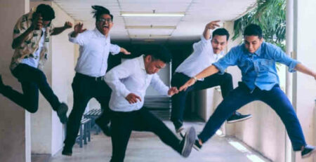 Business people jumping in the air in a hallway.