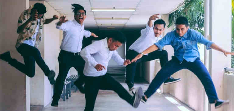 Business people jumping in the air in a hallway.
