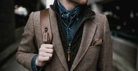 Someone stands wearing a blue shirt and a jacket.