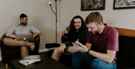 Three people laughing while having a business meeting.