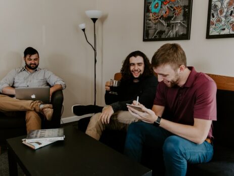 Three people laughing while having a business meeting.