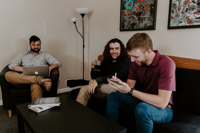 Three people laughing while having a business meeting.