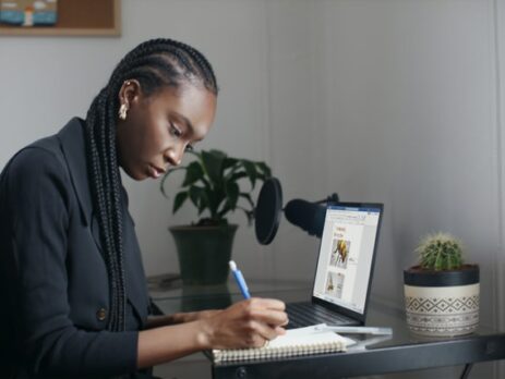 A person in a black shirt performs research on a laptop computer.