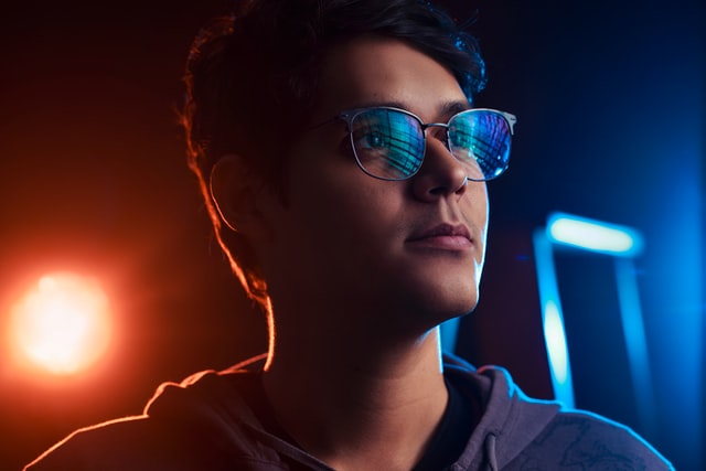Numbers on a screen are reflected in a person’s glasses.