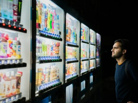 A man’s face lit up by a vending machine.