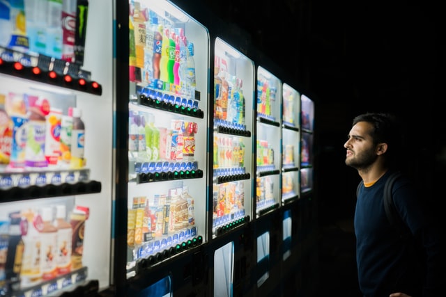 A man’s face lit up by a vending machine.