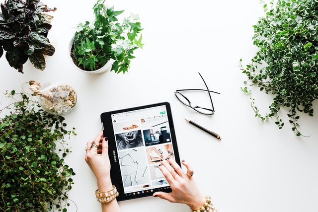 Someone using a tablet to access social media against a white background.