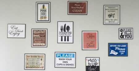 Various framed signs hanging on a white wall.