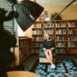 A crew filming an interview with a woman in a library.