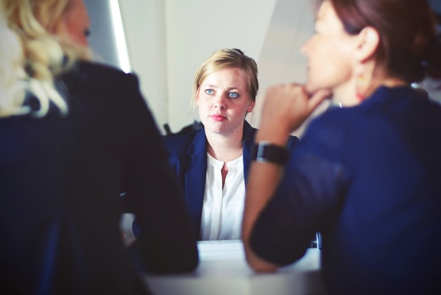 A woman speaks with job candidates.