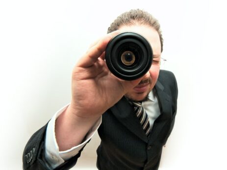 A man looks out through a telescope.