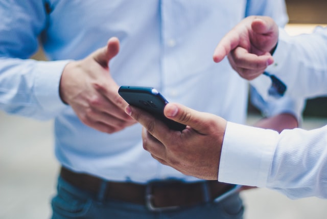 A person points at something on their phone.